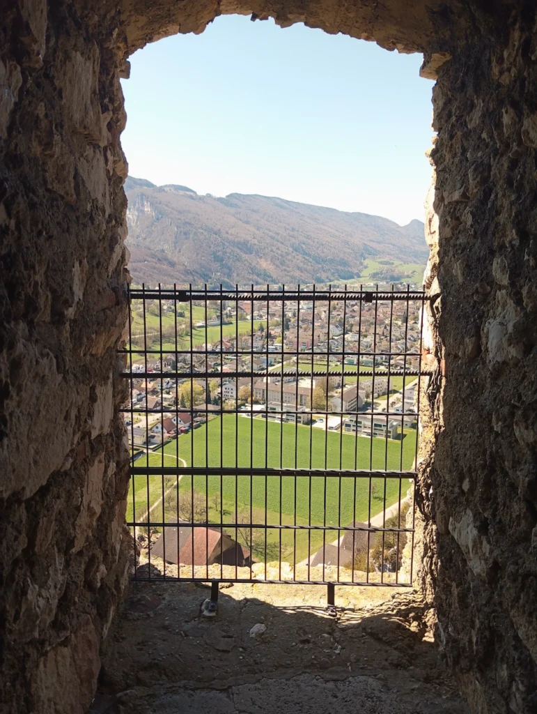 schöne Aussicht aus einem Burgfenster auf ein kleines Dort mit sonnigem Wetter