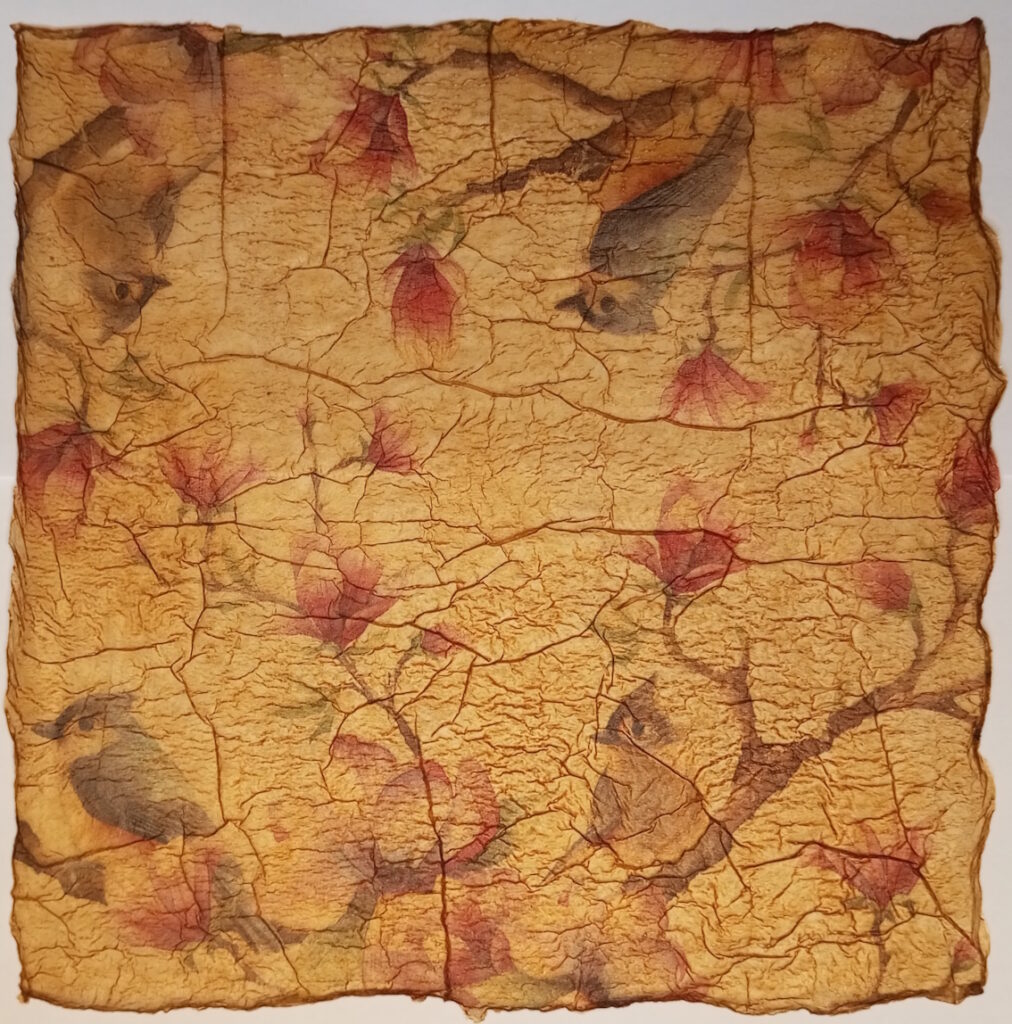Aus Servietten handgemachtes Papier im Vintage-Look mit Vögeln, die auf Ästen mit Blüten sitzen