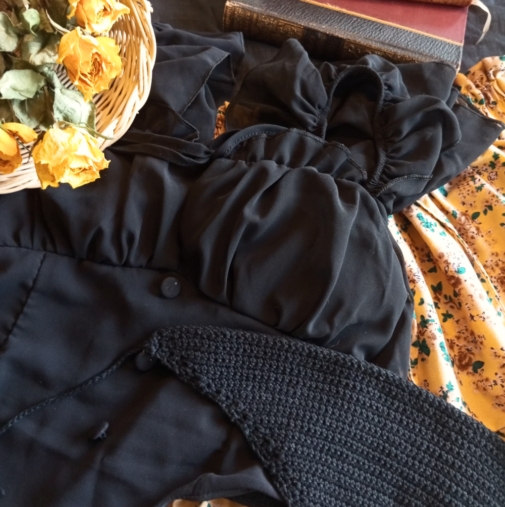 Bereitgelegte Klamotten im Dark Cottagecore Look, schwarz gelb . mit gelben, getrockneten Rosen
