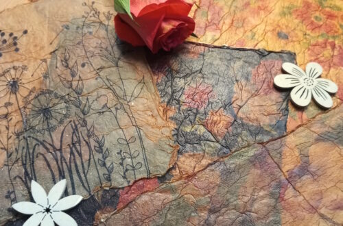 Selbstgemachte Bastelpapiere aus Servietten im Vintage-Stil, dekoriert mit einer Rose und Blumen aus Holz