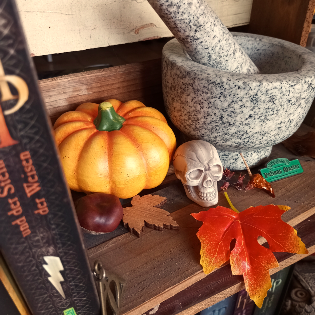 Dekoration im Herbst & Harry Potter Stil mit einem Mörser, Kürbis, Totenkopf, Bücher und Naturmaterialien
