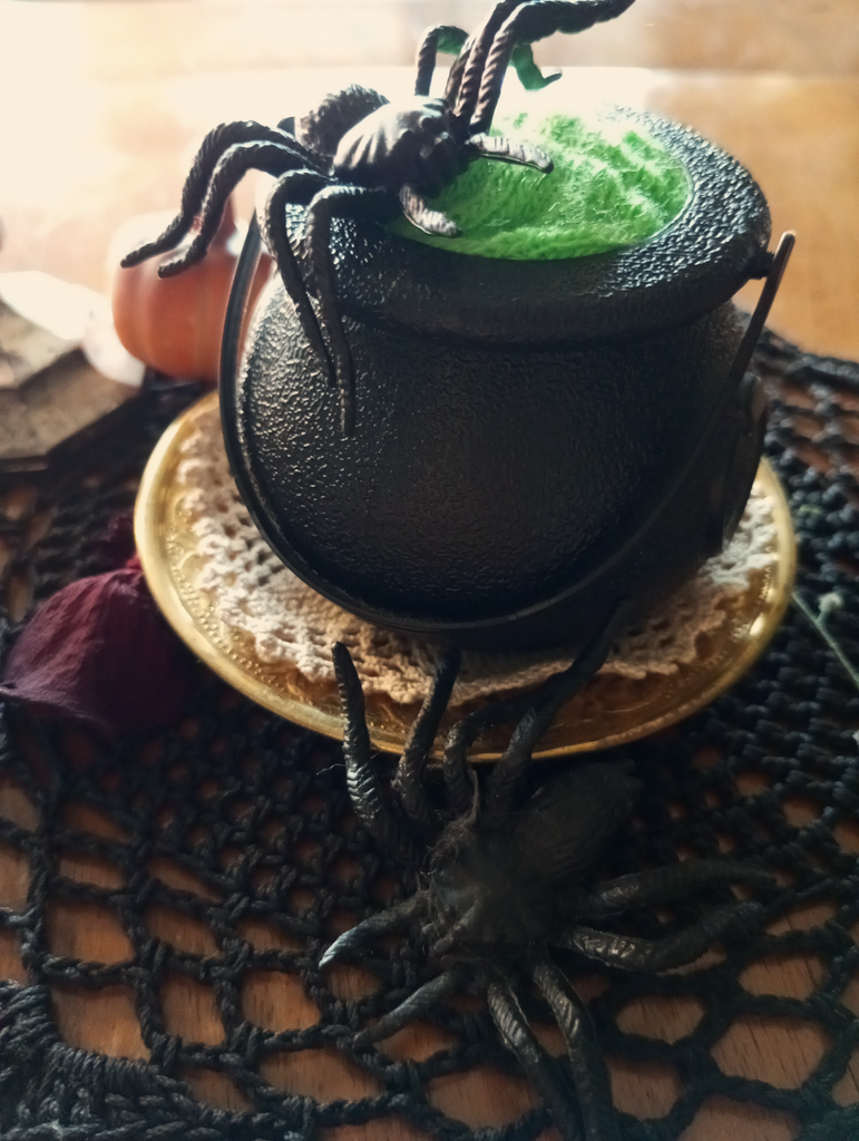 Halloweendekoration: ein Hexenkessel mit künstlichen Spinnen