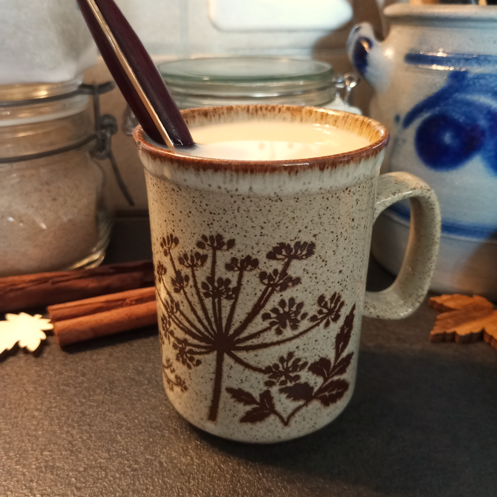 Pumpkin Spice Latte in einer herbstlichen Tasse mit Zimt zur Deko
